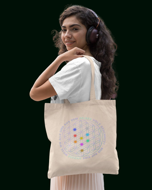 Ein nachhaltiger Jutebeutel aus recycelter Baumwolle und recycelter Polyester in Naturfarbe (besch) - verziert mit der Blume des Lebens auf der einen und dem Alpha-i-Omega auf der anderen Seite. Perfekt für Freizeit, Arbeit, Universität und Festivals – stilvoll und umweltfreundlich