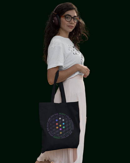 Ein nachhaltiger Jutebeutel aus recycelter Baumwolle und recycelter Polyester in Schwarz - verziert mit der Blume des Lebens auf der einen und dem Alpha-i-Omega auf der anderen Seite. Perfekt für Freizeit, Arbeit, Universität und Festivals – stilvoll und umweltfreundlich